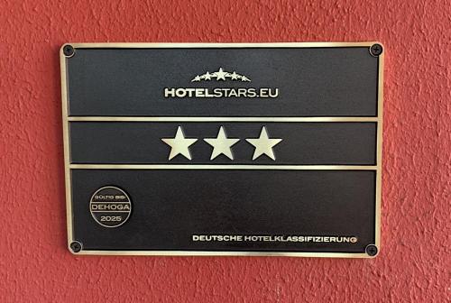un cartel en una pared con cuatro estrellas en Hotel Wittgensteiner Hof, en Bad Laasphe