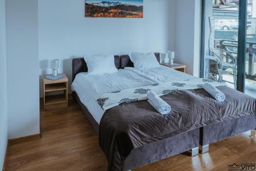 a large bed in a room with a window at Kompleks Tawerna Vito - Apartamenty Vito in Czorsztyn