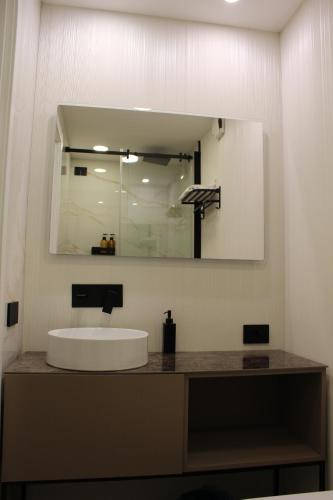 a bathroom with a sink and a large mirror at Nero Luxury Suites in Cagliari