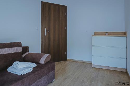 a living room with a couch and a dresser at Kompleks Tawerna Vito - Apartamenty Vito in Czorsztyn