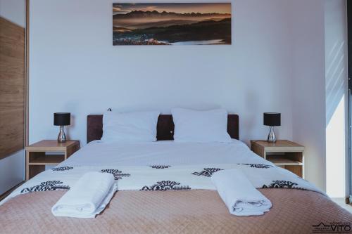 a bedroom with a large white bed with two night stands at Kompleks Tawerna Vito - Apartamenty Vito in Czorsztyn