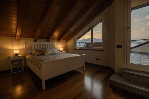 una camera da letto con un letto con due lampade e una finestra di Attico Borromea a Leggiuno