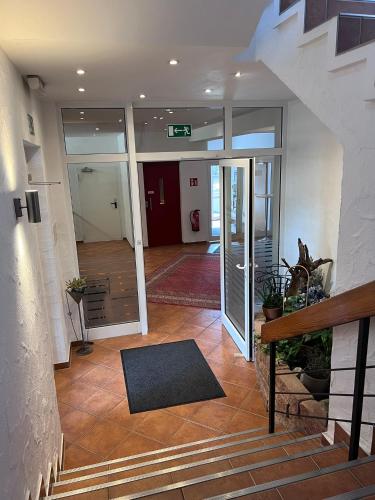 an empty lobby with a staircase and aoyer with glass doors at Hotel Wittgensteiner Hof in Bad Laasphe