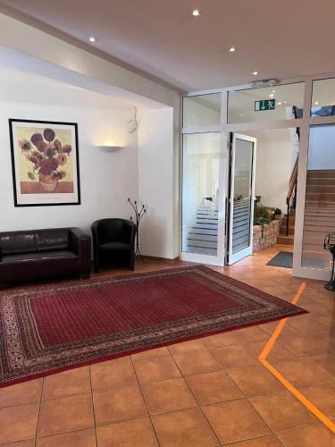 a living room with a black couch and a rug at Hotel Wittgensteiner Hof in Bad Laasphe