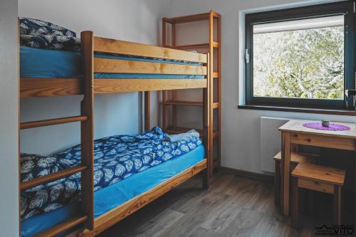 a bedroom with bunk beds and a desk and a window at Kompleks Tawerna Vito - Apartamenty Vito in Czorsztyn