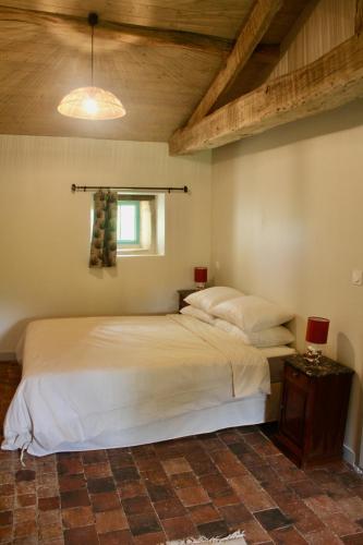 une chambre avec un grand lit et une table dans l'établissement Le Cerisier at Closerie Les Roches - 2 Bed Country Cottage, à Bouillé-Loretz