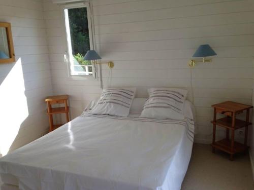 una camera con un letto bianco con due cuscini di Attractive holiday home with garden a Saint-Marcet