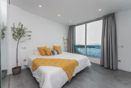 a bedroom with a large bed and a large window at Gold Suite Canteras by Canarias Homelidays in Las Palmas de Gran Canaria