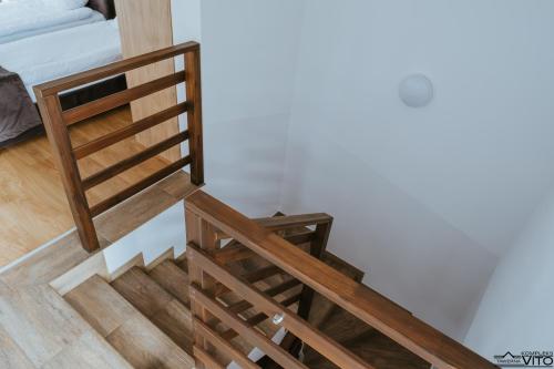 a wooden staircase in a room with a bed at Kompleks Tawerna Vito - Apartamenty Vito in Czorsztyn