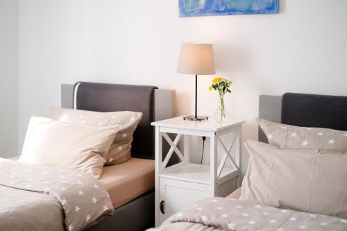a bedroom with a bed and a table with a vase of flowers at GästeHaus am Flughafen Düsseldorf in Düsseldorf