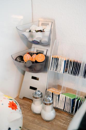 a table with a shelf with a bowl and some food at GästeHaus am Flughafen Düsseldorf in Düsseldorf