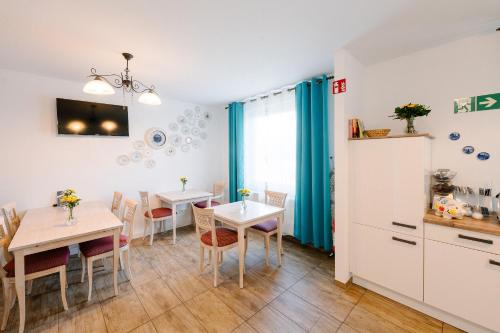 a kitchen and dining room with two tables and chairs at GästeHaus am Flughafen Düsseldorf in Düsseldorf