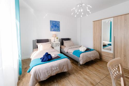 a bedroom with two beds and a chandelier at GästeHaus am Flughafen Düsseldorf in Düsseldorf