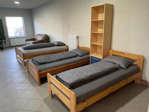 Cette chambre comprend trois lits et une chaise. dans l'établissement Grande, à Mediaş