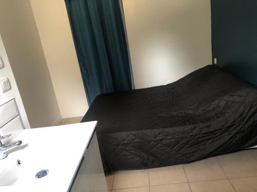 een badkamer met een bed met een zwart laken bij Caussada in Caussade