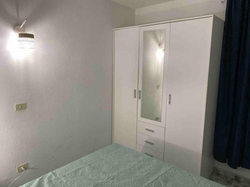 a white bedroom with a bed and a mirror at Apartment with sea view! Mesa del Mar 120 in Santa Cruz de Tenerife