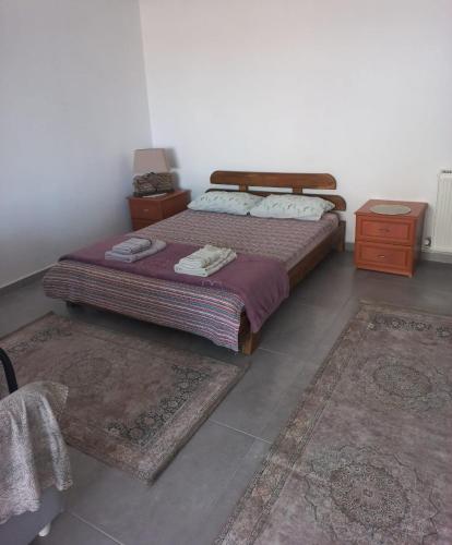 1 dormitorio con 1 cama y 2 alfombras en GÜLBEYAZ PANSİYON, en Dikili