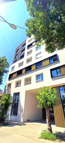 a large white building with a garage at Lux apartment 13 center, free parking in Niš