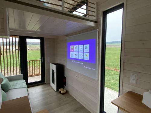 a living room with a large screen in a house at Tiny Cosy in Bastogne