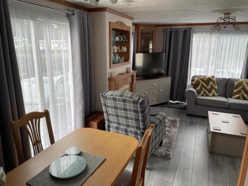a living room with a table and a couch at Luxury modern caravan Seton Sands in Port Seton