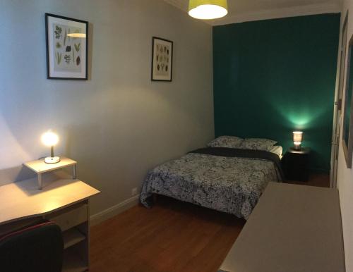 - une chambre avec un lit, une table et deux lampes dans l'établissement Bel appartement à Dijon 1, à Dijon