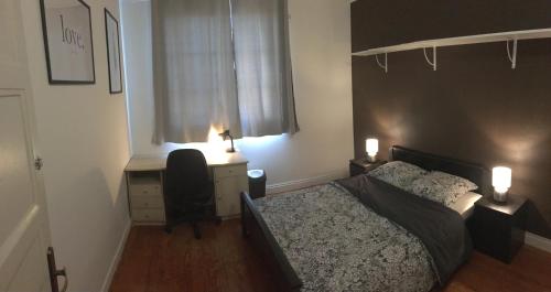 um quarto com uma cama e uma secretária com 2 candeeiros em Bel appartement à Dijon 1 em Dijon