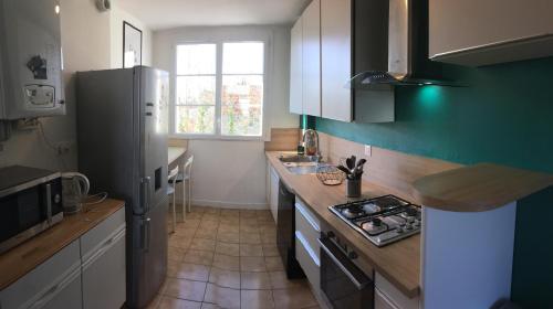 uma cozinha com um frigorífico e uma bancada em Bel appartement à Dijon 1 em Dijon