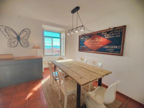 una sala da pranzo con tavolo e sedie in legno di Apartmento com vista incrivel a Lisbona