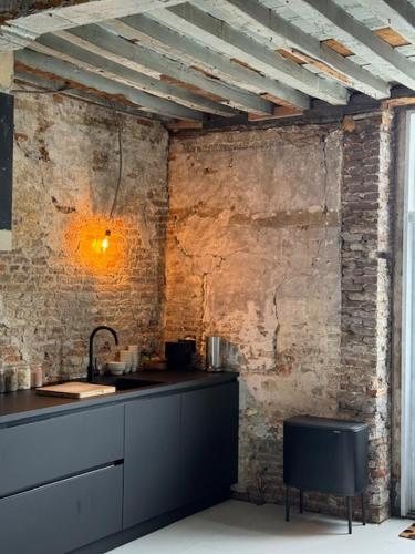 a kitchen with a sink and a brick wall at Cloud9 in Bergen op Zoom