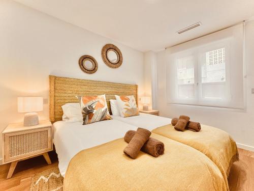 twee bedden in een slaapkamer met twee bruine handdoeken bij Casa Natura Levante Beach in Santa Pola