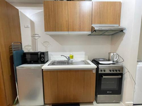 a small kitchen with a sink and a microwave at 8 Adriatico in Manila