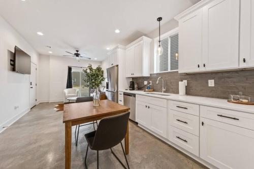 a kitchen with white cabinets and a wooden table at Creole House/KING bed/Relax in Cajun Comfort! in Lafayette