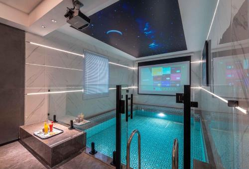 a bathroom with a swimming pool with a projection screen at Boudl Khamis Mushait in Khamis Mushayt