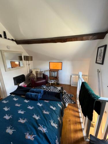 a bedroom with a bed with a blue blanket with horses on it at The Hanging Gate Coach House in Madeley