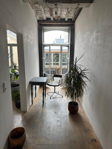 een kamer met een bureau, een tafel en een plant bij Cloud9 in Bergen op Zoom