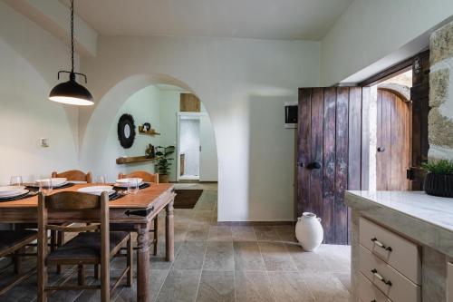 a kitchen and dining room with a wooden table and chairs at To Patriko in Kournás