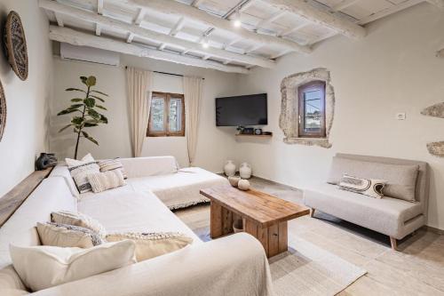 een woonkamer met twee witte banken en een tafel bij To Patriko in Kournás