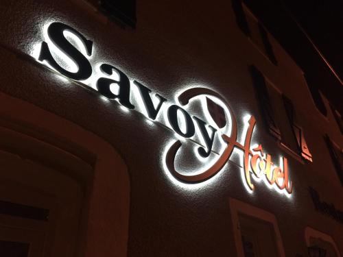 a neon sign on the side of a building at Savoy Hotel in Le Bourget-du-Lac
