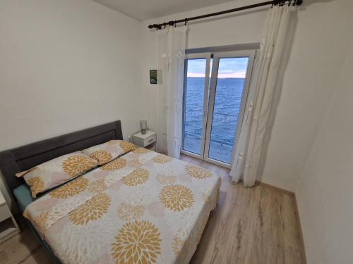 a bedroom with a bed and a large window at Apartment Lisarica in Starigrad-Paklenica