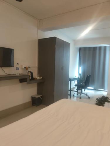a hotel room with a bed and a desk and a chair at Yummy land guest house in Imphal