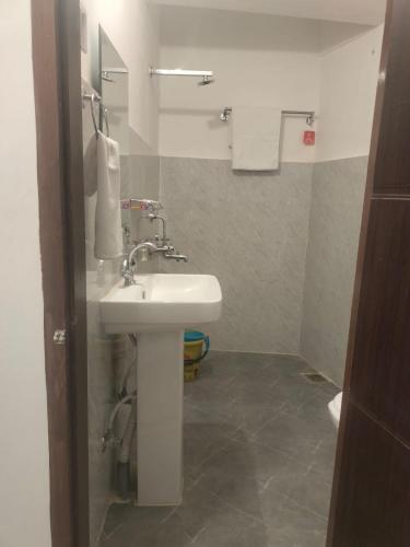 uma casa de banho com um lavatório branco e um espelho. em Yummly land guest house em Imphal