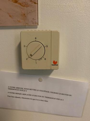 a clock on a wall with a sign on it at Le relax de panne in De Panne