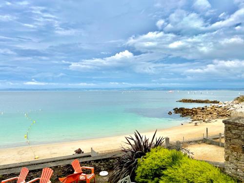 a view of a beach with chairs and the ocean at Glaz Ocean in Douarnenez