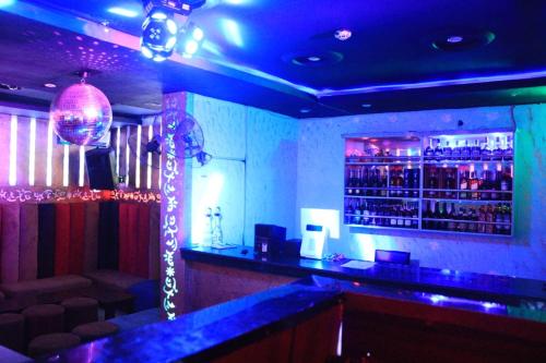 eine Bar mit blauer Beleuchtung und einer Bartheke in der Unterkunft Rocket Room Hotel & Suites Limited in Port Harcourt