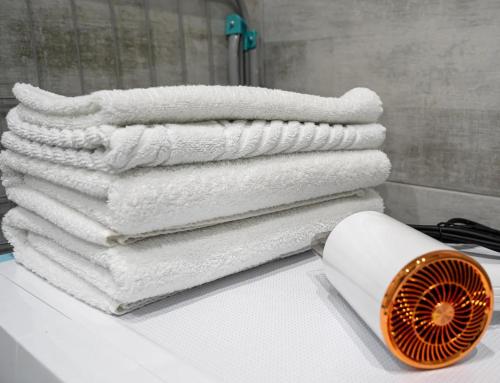 a pile of towels on a table with a fan at Warm cozy apartment with fast wi-fi in Tbilisi City