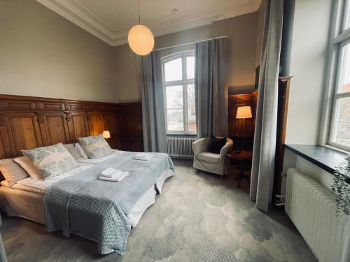 1 dormitorio con 1 cama, 1 silla y ventanas en Stationen, en Ystad