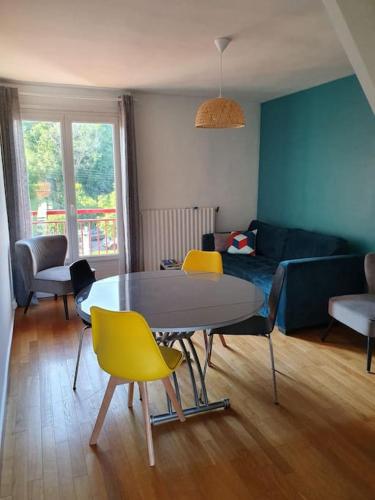 un salon avec une table et des chaises jaunes dans l'établissement Appartement , 6 personnes, centre-ville, plage à pied, à Saint-Jean-de-Luz
