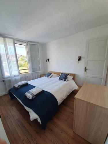 une chambre avec un grand lit et un parquet dans l'établissement Appartement , 6 personnes, centre-ville, plage à pied, à Saint-Jean-de-Luz