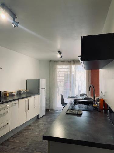 une cuisine avec des armoires blanches et une table à l'intérieur dans l'établissement L'évasion and work, au Thor