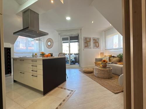 a kitchen and living room with a stove top oven at Ático Luz y Mar in Cambados